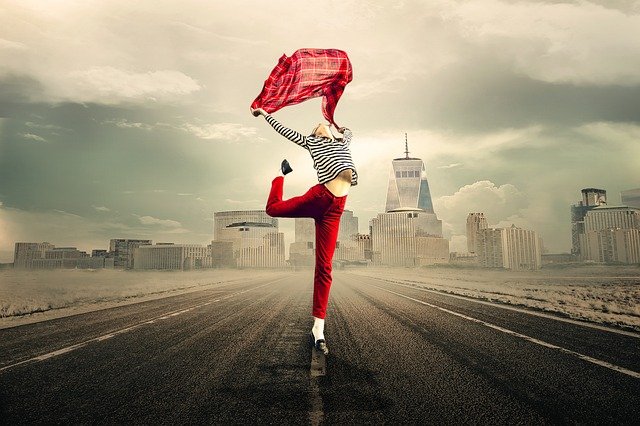 Femme avec un foulard et sautant sur une route